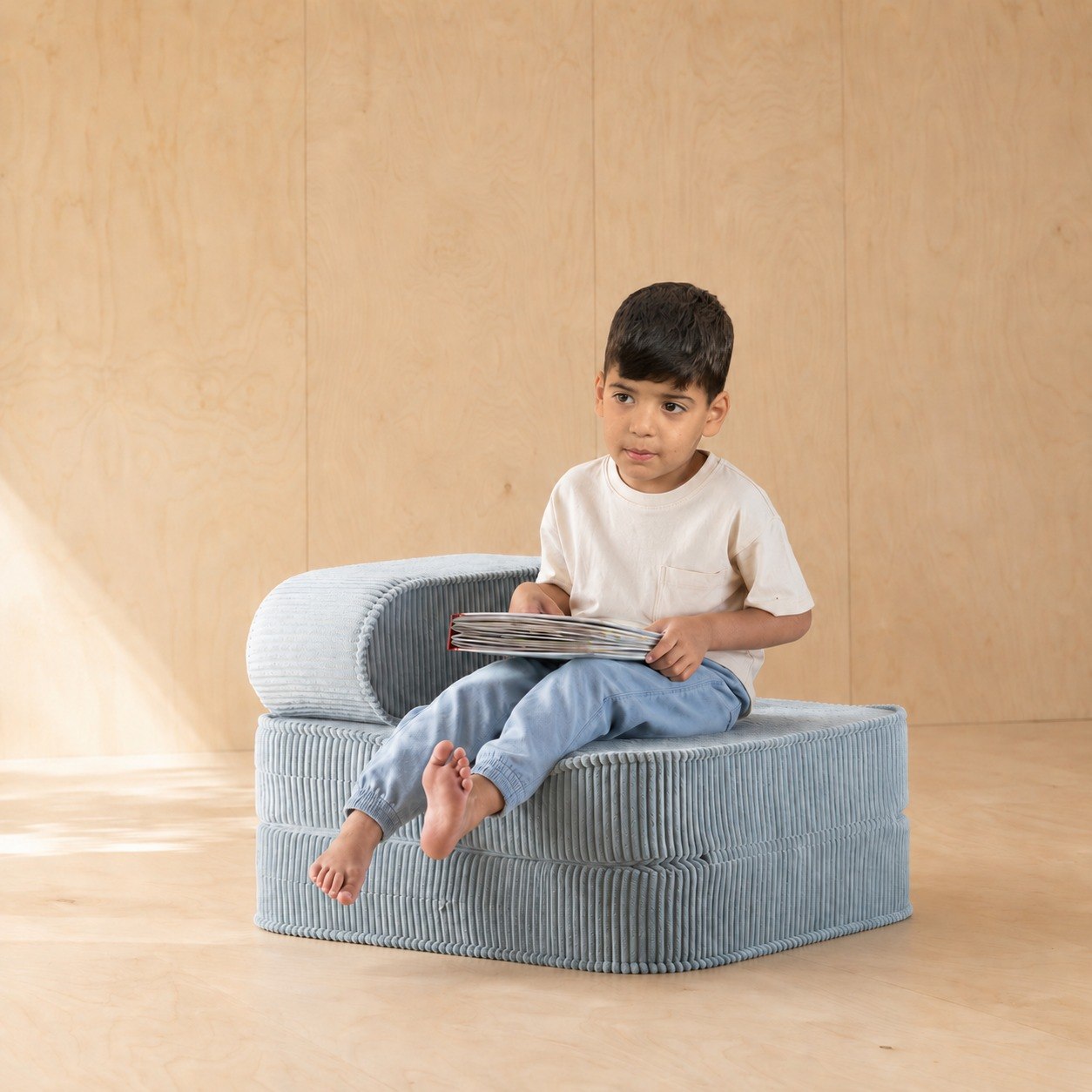 כורסת פליפ Flip Chair מבד קורדרוי תכלת עם ילד יושב וקורא בחדר ילדים - RANCO